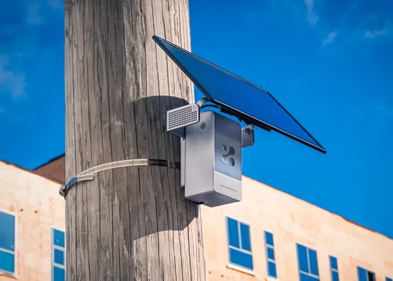 Aethair PRO strapped to a wooden utility pole with its solar panel above it.