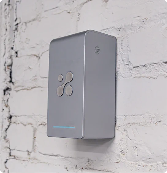 Aethair PRO mounted to a white brick wall.