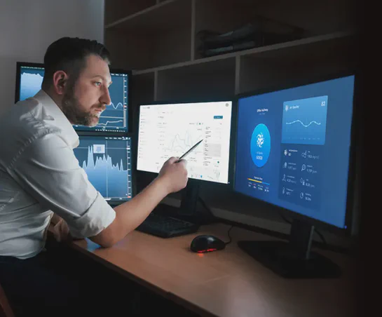 Man sitting at a monitoring control center viewing both Environet and an Aethair dashboard.