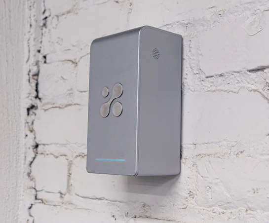 Aethair PRO mounted to a white brick wall.