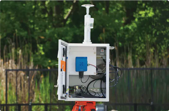 Aethair Thiamis connected to a TSI DustTrak PM monitor inside a weatherproof box with a heated inlet.