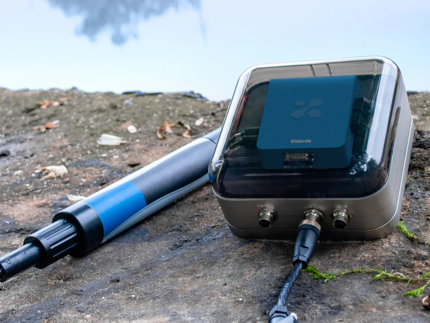 Thiamis in its weatherproof field case on open ground, with a probe cabled to it.