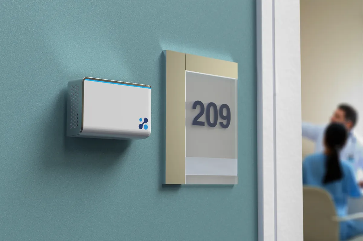 Aethair IAQ mounted to green wall next to room number sign