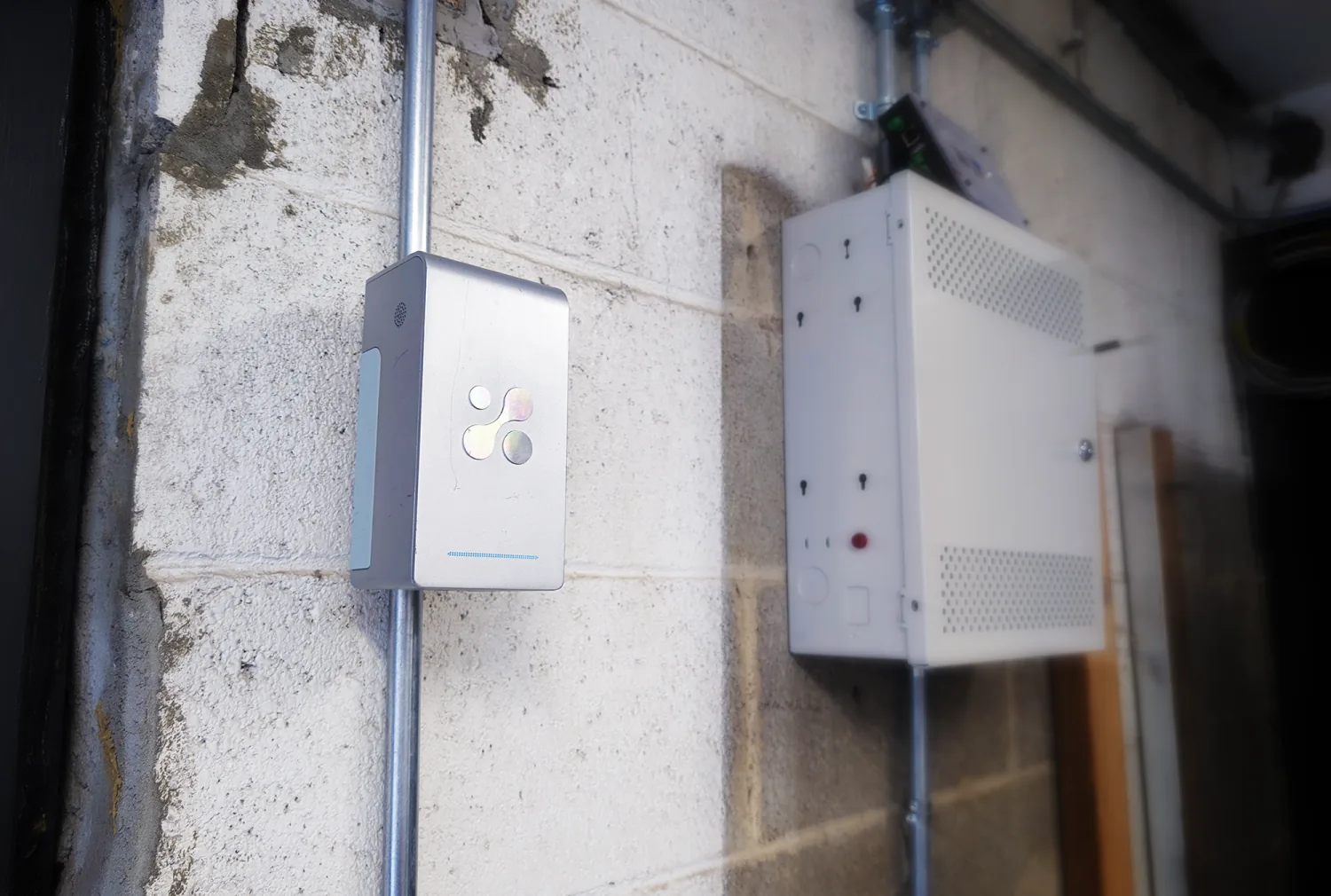 Aethair PRO mounted as an area monitor on a cinder-block garage wall.