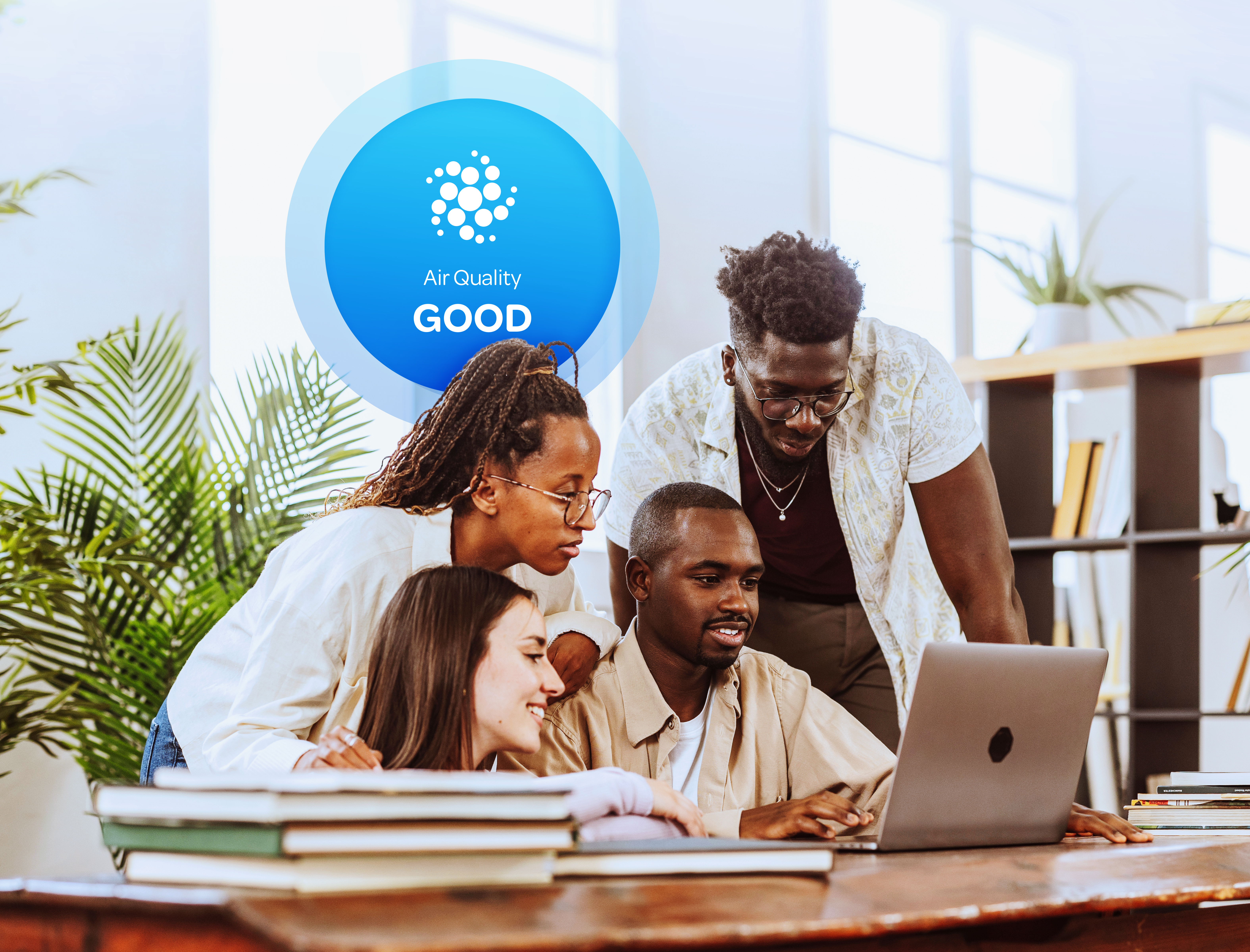 Community members reviewing air quality data on a laptop with Aethair “Good” air quality status displayed behind them.