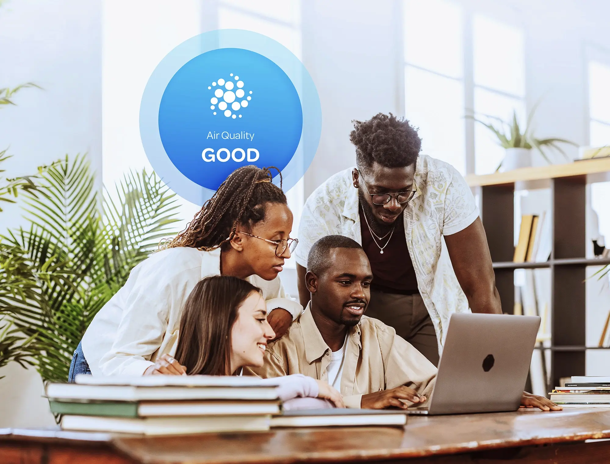 Community members reviewing air quality data on a laptop with Aethair “Good” air quality status displayed behind them.