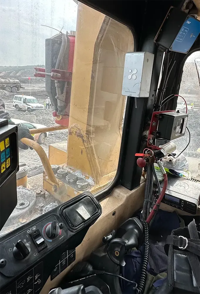 Aethair PRO installed inside the operator cabin of heavy mining equipment, mounted on the cab pillar beside the window.