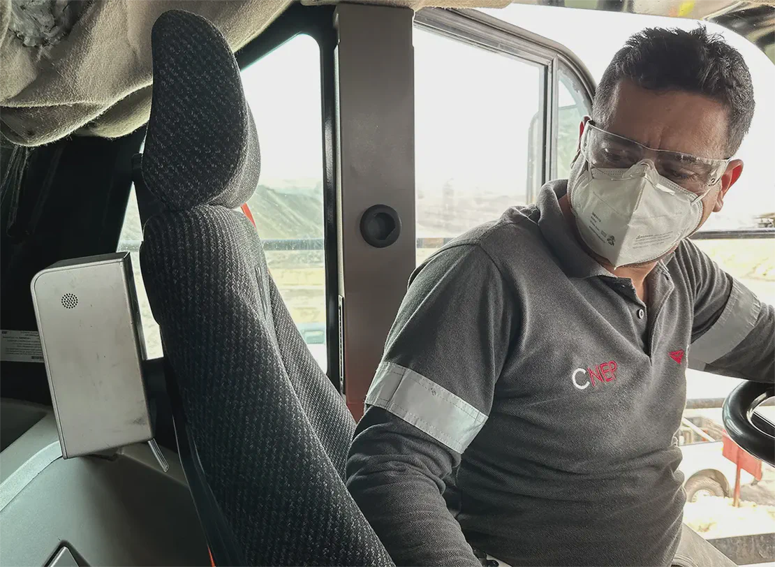Mining equipment operator seated in heavy equipment looking at an Aethair PRO mounted beside the seat.