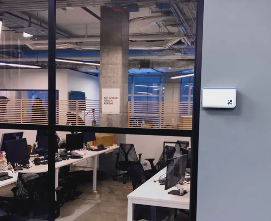 An Aethair IAQ air quality monitor in a school computer lab.