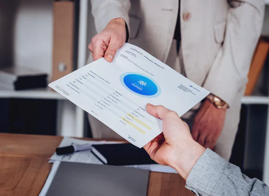 Hands holding a printed Aethair air quality report used for board and compliance reporting.