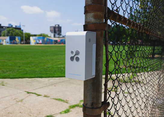 Aethair PRO outdoor air quality monitor with a solar panel mounted on a pole.