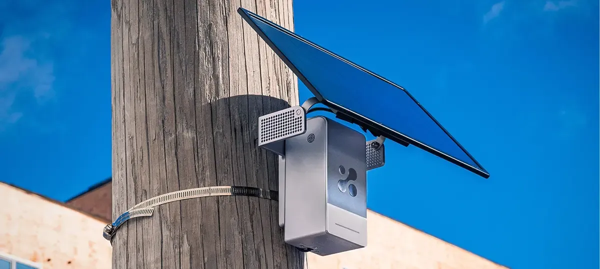 Aethair PRO with a solar panel, strapped to a wooden utility pole outdoors.