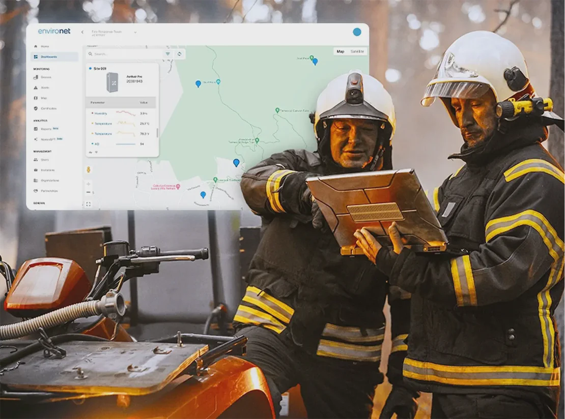 Two wildland firefighters reviewing Aethair PRO monitoring data on a laptop during a wildfire.